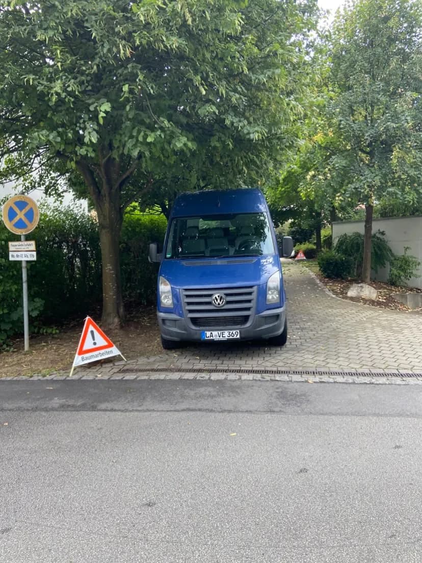 Abgesichertes Einsatzfahrzeug mit Warnschild „Baumarbeiten"